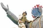 Un soldado estadounidense tapa, con la bandera de su país, una estatua de Sadam Hussein