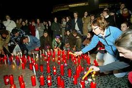 Ciudadanos encendiendo velas en homenaje a los muertos